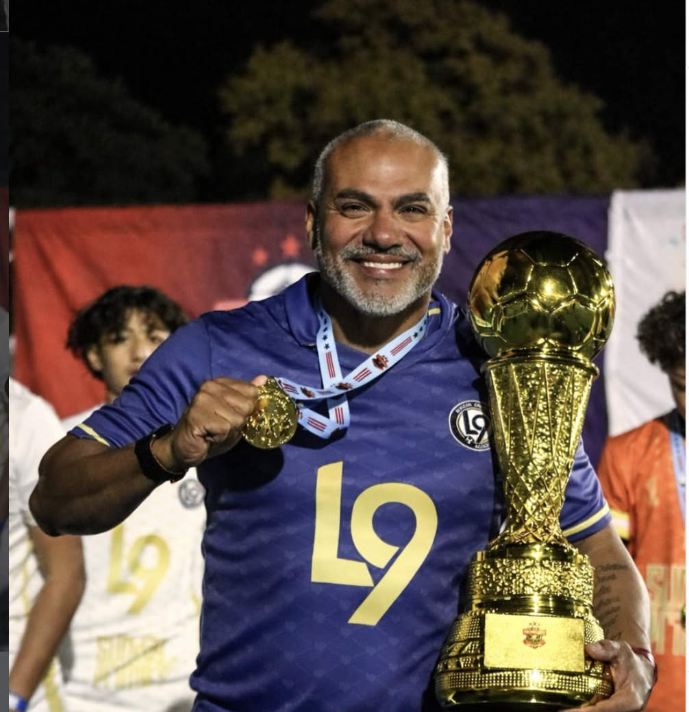 Leandro Mofacto, founder of L9 Soccer Center, holding the championship trophy